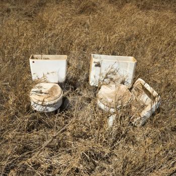 Royalty Free Photo of Old Toilets That Were Dumped in a Field