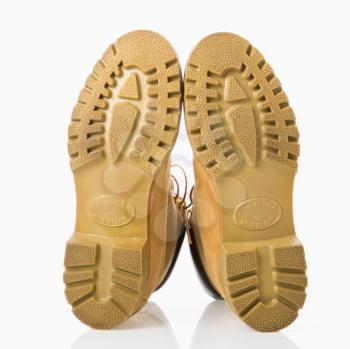 Royalty Free Photo of a Pair of Tan Construction Boots With Soles Up