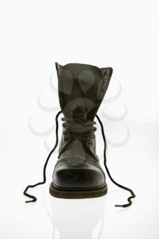 Royalty Free Photo of One black leather high top boots with untied laces