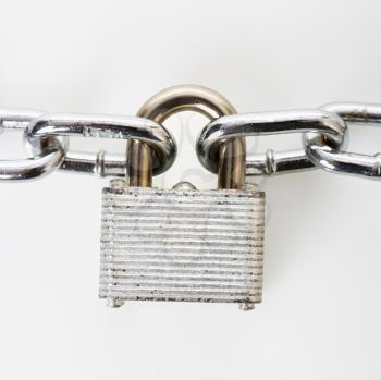 Royalty Free Photo of a Metal Padlock Locked to Chains