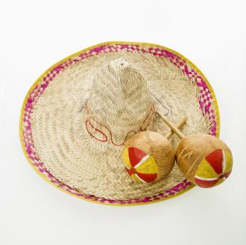 Pair of handmade Mexican maracas percussion musical instruments on sombrero straw hat.