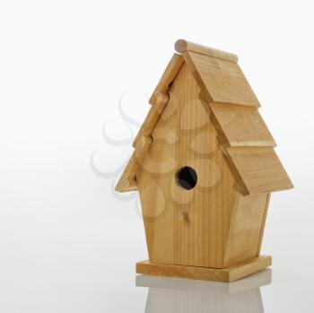 Wooden birdhouse against white background.