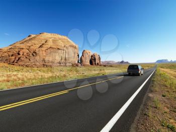 Royalty Free Photo of a Car Driving on a Highway in the Desert