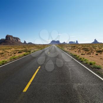 Royalty Free Photo of an Open Highway in Scenic Desert Landscape With Distant Mountains and Mesas