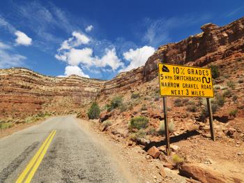 Royalty Free Photo of a Road sign warning steep grade through rocky Utah landscape