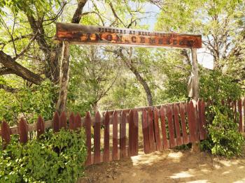 Royalty Free Photo of a Pioneer Cemetery Entrance With Gate and Sign in Woods