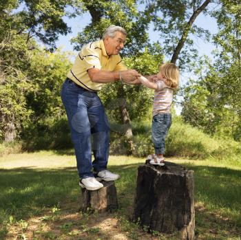 Royalty Free Photo of Grandfather and Granddaughter Playing Outside
