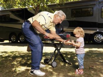 Royalty Free Photo of a Grandfather Giving His Granddaughter a Hotdog by RV
