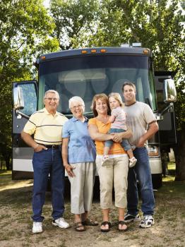 Royalty Free Photo of a Portrait of a Three Generation Family Standing in Front of a Recreational Vehicle Smiling
