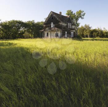 Royalty Free Photo of an Abandoned Farm House in a Rural Field