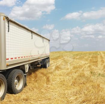 Royalty Free Photo of a Tractor Trailer Truck in a Harvested Crop Field
