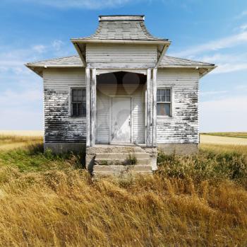 Royalty Free Photo of Weathered Building With Peeling Paint in Grasslands
