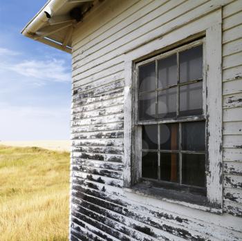 Royalty Free Photo of an Abandoned Building With Peeling Paint in Grassland