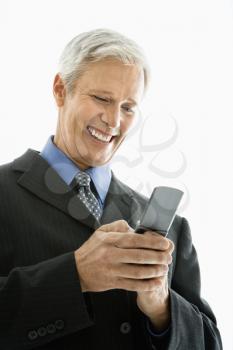 Royalty Free Photo of a Businessman Smiling and Text Messaging on a Cellphone