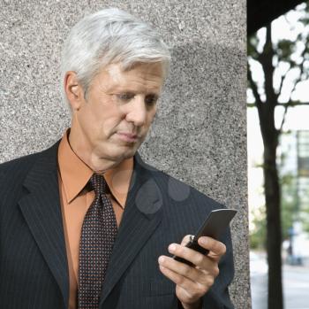 Royalty Free Photo of Businessman Looking at His Cellphone