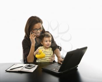 Royalty Free Photo of a Businesswoman Talking on a Cellphone With a Toddler on Her Lap