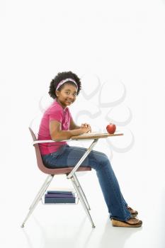 Royalty Free Photo of a Girl Sitting in a School Desk Smiling