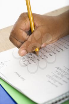 Royalty Free Photo of a Girl at School Writing in a Notebook With a Pencil