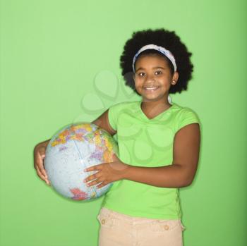 Royalty Free Photo of an African American Girl Holding a Globe at Hip and Smiling
