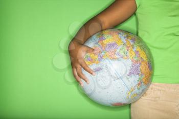 Royalty Free Photo of an Arm of an African American Girl Holding a Globe at Hip