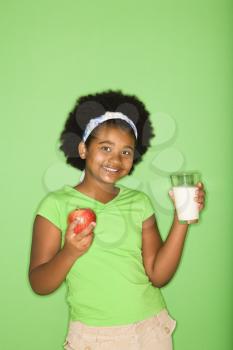 Royalty Free Photo of a Girl Holding a Glass of Milk and an Apple