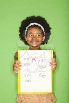 Royalty Free Photo of a Girl Holding a School Assignment and Smiling Proudly