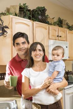Royalty Free Photo of a Family Standing in a Kitchen Smiling