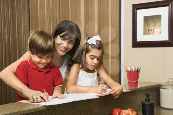 Royalty Free Photo of a Mother and Children Smiling While Doing Homework