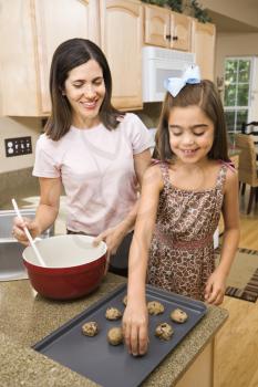 Royalty Free Photo of a Mother and Daughter Making Cookies Smiling