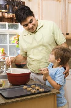 Royalty Free Photo of a Father and Son in the Kitchen Making Cookies