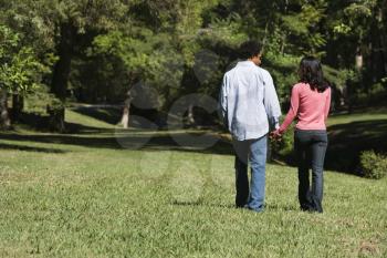 Royalty Free Photo of a Couple Holding Hands Walking and Talking in a Park