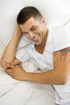 Royalty Free Photo of a Handsome Man Lying in Bed Smiling
