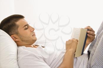 Royalty Free Photo of a Man Reading in Bed