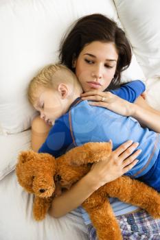 Royalty Free Photo of a Mother With Toddler Son Sleeping in Bed