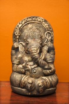 Royalty Free Photo of a Statue of a Hindu Elephant Ganesha Against an Orange Wall