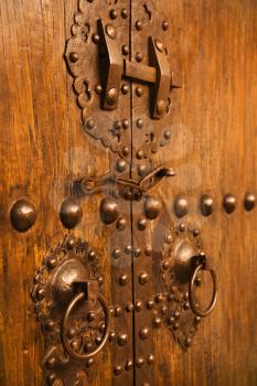 Royalty Free Photo of Wooden Doors With Ornate Metal Knobs and Locks