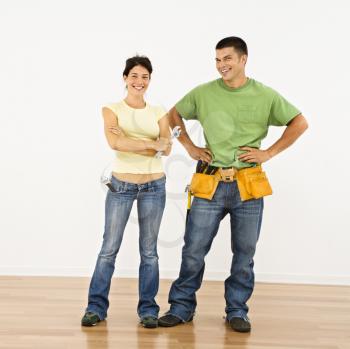 Royalty Free Photo of a Couple With Tools Standing and Smiling in Home