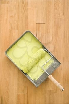 Royalty Free Photo of a Paint Roller in a Tray on Wood Floor