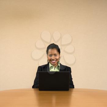 Royalty Free Photo of a Businesswoman Sitting at a Conference Table Typing on a Laptop Computer