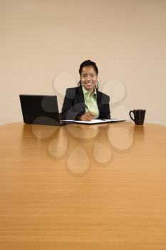 Royalty Free Photo of a Businesswoman Sitting at a Conference Table Working