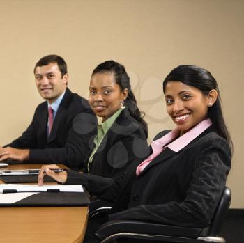 Royalty Free Photo of Businesspeople Sitting at a Conference Table Smiling