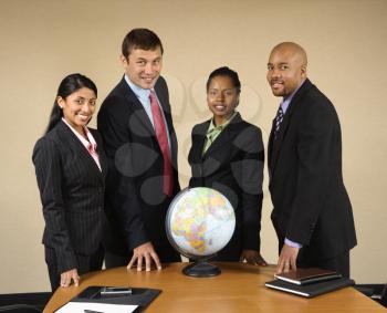 Royalty Free Photo of Businesspeople Standing Around a Globe Smiling