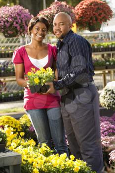 Royalty Free Photo of a Smiling Couple Picking out Flowers at an Outdoor Plant Market