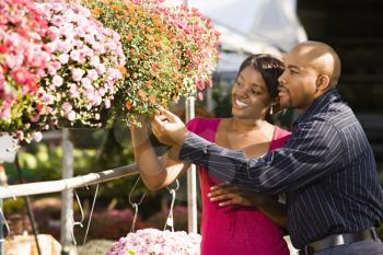 Royalty Free Photo of a Happy Smiling Couple Picking Out Flowers at an Outdoor Plant Market