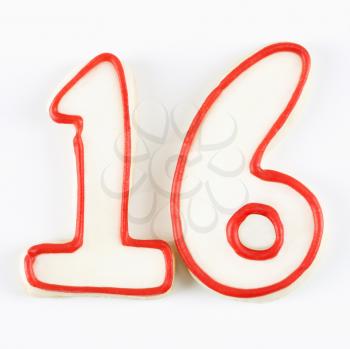 Sugar cookies in the shape of the number sixteen outlined in red icing.