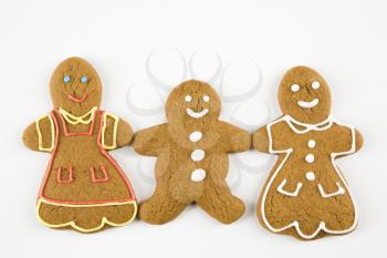 Three male and female gingerbread cookies holding hands.