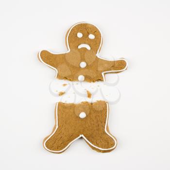 Royalty Free Photo of a Frowning Gingerbread Cookie Broken in Half