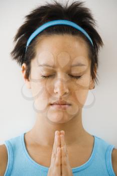 Royalty Free Photo of a Woman Holding Hands in Prayer Position With Eyes Closed Meditating