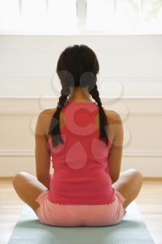 Royalty Free Photo of a Woman Sitting on a Yoga Mat