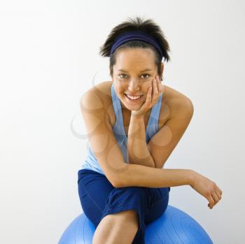 Royalty Free Photo of a Woman Sitting on a Fitness Balance Ball Smiling